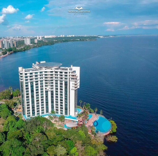 A high-rise hotel with a pool and a view of the sea. - Tropical Executive Hotel - FLAT (Manaus)