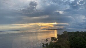 A coastal landscape with a body of water reflecting the sky. - Tropical Executive Hotel - FLAT (Manaus)