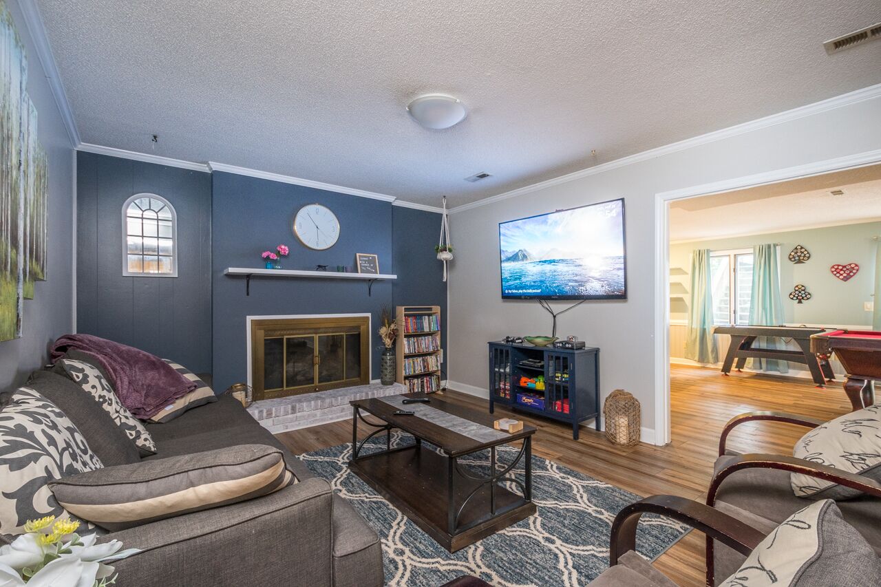 A living room with a fireplace, a TV, a bookshelf, and a sofa.