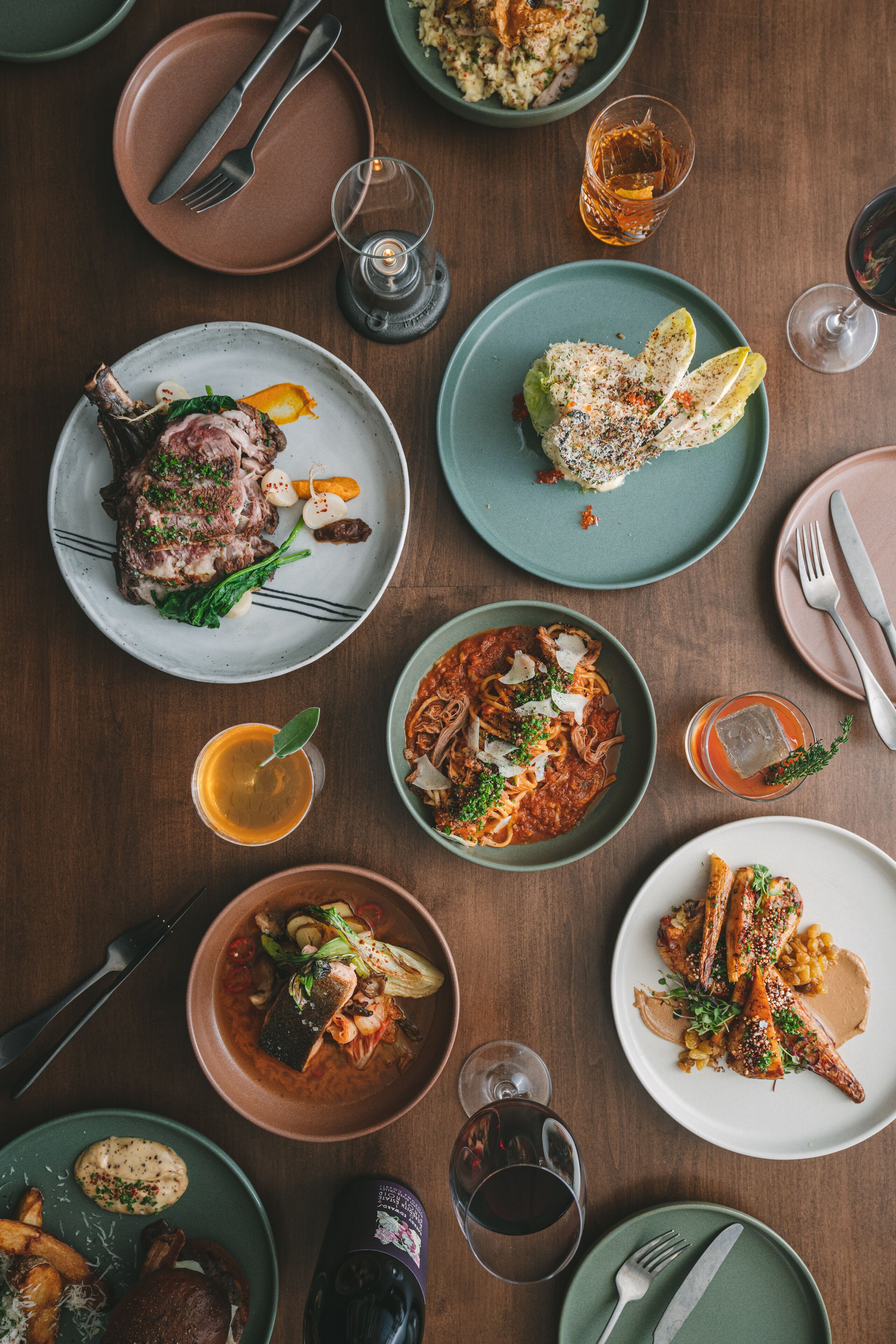 A dining table with various dishes and glasses of beverages.