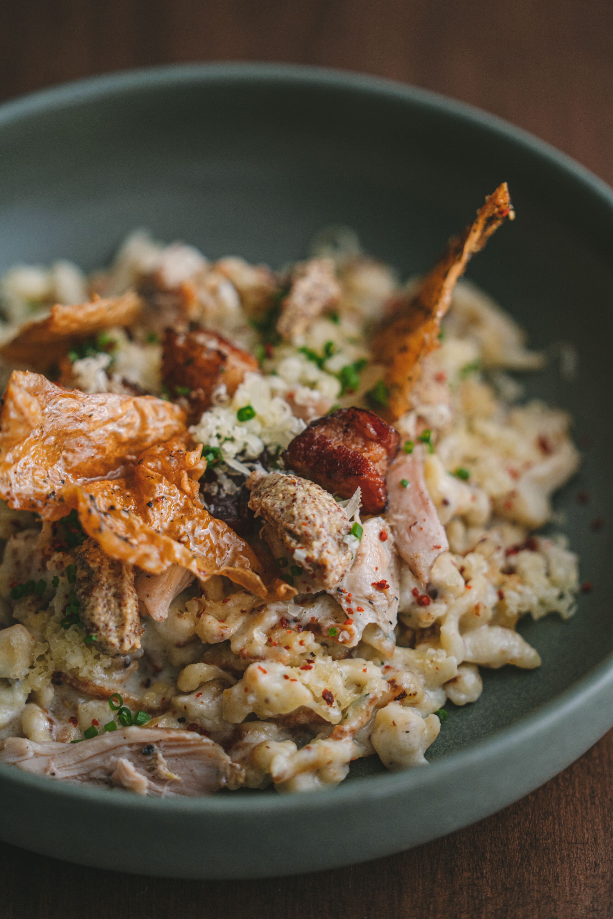 A bowl of food with rice, meat, and garnishes.