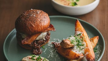 A plate with a burger, fries, and a bowl of soup.
