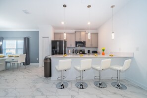 Enjoy meals in the central island kitchen with stainless steel appliances and dining area.