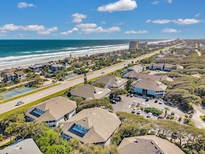 Una zona residencial costera con casas, una carretera y una playa.