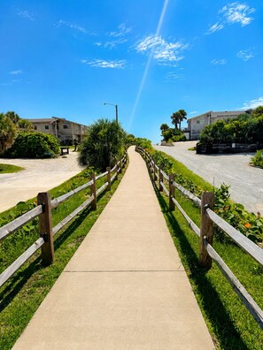 A pathway leading to a building with a wooden fence on both sides.