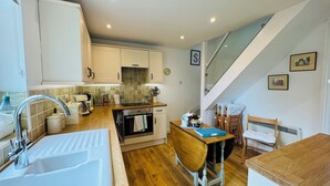 A compact kitchen with a sink, stove, and dining area.