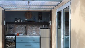 A compact kitchen with a stove, oven, refrigerator, and blue cabinetry. - Off grid living! Enjoy and love the Nature! (Savaneta)