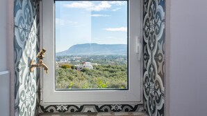 Een badkamer met uitzicht op een bergachtig landschap.