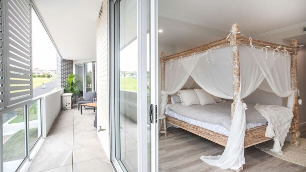 A balcony with a view of a road and greenery, a bed with a canopy, and a chair. - Casa del Navilla - Experience luxurious living right on Ulladulla Harbour (Ulladulla)