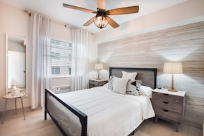 A bedroom with a bed, bedside tables, a ceiling fan, and a window with curtains. - On Beach, 3rd/Ocean, Pool, SOFI (Miami Beach)