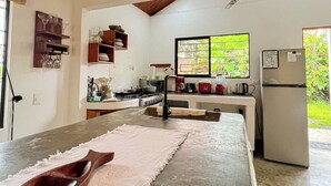 Cocina con una isla grande, techo de madera y vistas a zonas verdes.