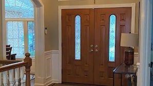 A wooden-floored entrance with a double door, a staircase, and a chandelier. - Lakeside Retreat Entire House Inground pool, kayaks, dock (Cross Hill)