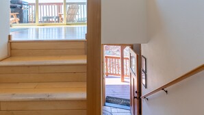 Una scala in legno con vista su una terrazza esterna e un'area coperta.