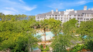 A large hotel with a central swimming pool surrounded by lush greenery and trees. - Grand Sandestin by Baytowne Wharf Village at Sandestin Golf & Beach Resort.   (Miramar Beach)