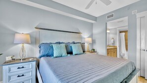 A bedroom with a bed, bedside tables, a nightstand, a dresser, and a bathroom visible through an open door. - Grand Sandestin by Baytowne Wharf Village at Sandestin Golf & Beach Resort.   (Miramar Beach)