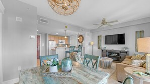 A modern kitchen with wooden cabinets, a microwave, and a dining area with a rustic table and chairs. - Grand Sandestin by Baytowne Wharf Village at Sandestin Golf & Beach Resort.   (Miramar Beach)