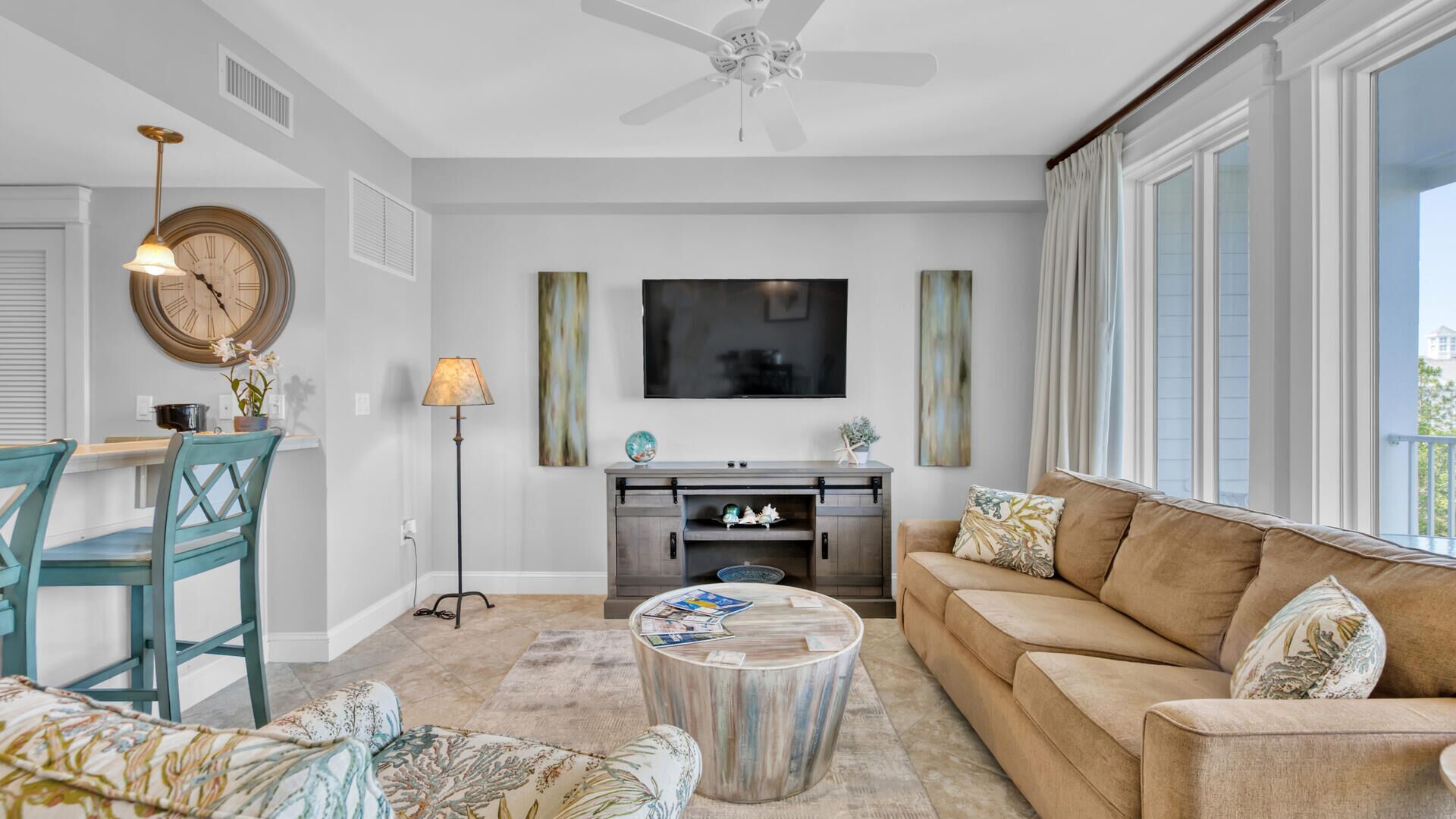 A living room with a sofa, coffee table, and a TV mounted on the wall.