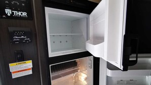 A compact refrigerator with a freezer compartment, a control panel with various settings, and a warning label. - Cozy place in Lake Worth (Lake Worth)