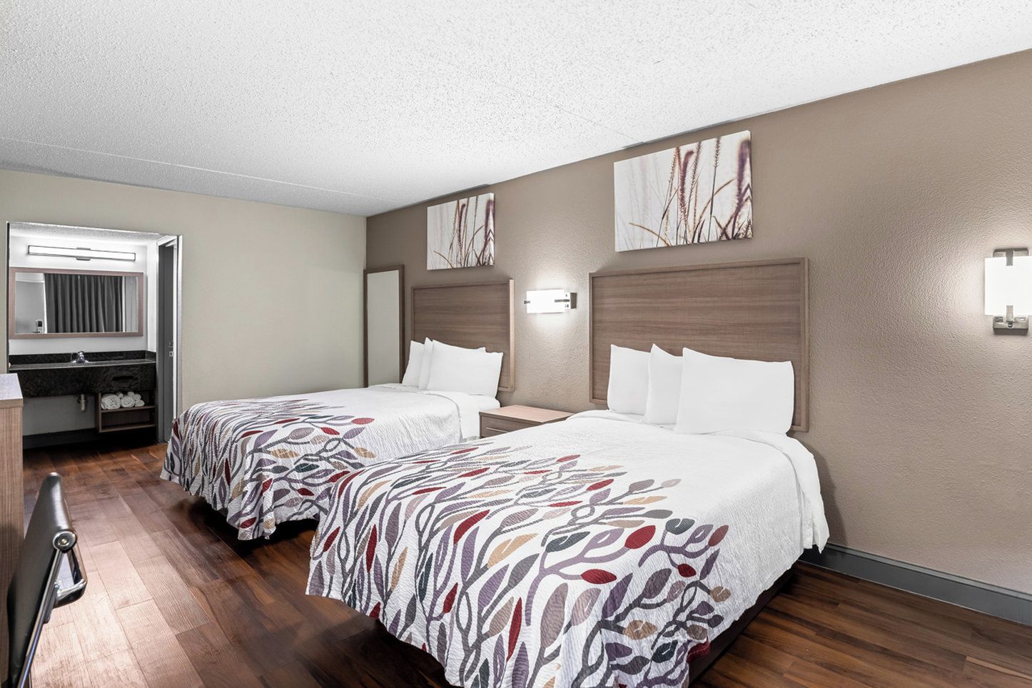 Une chambre d’hôtel avec deux lits, une salle de bain et un bureau.