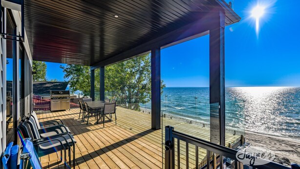 A wooden deck with outdoor furniture, a grill, and a view of the ocean. - 4bed 5bath brand new beach house in Tiny! West Exposure! Sunsets! Hot tub! (Tiny)