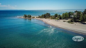 A coastal property with a sandy beach, clear blue waters, and a line of trees. - 4bed 5bath brand new beach house in Tiny! West Exposure! Sunsets! Hot tub! (Tiny)