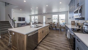 Una cocina moderna con una isla central, armarios de madera y electrodomésticos integrados.