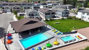 Zona residencial con casas modernas, piscina y un patio cubierto.