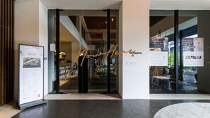 L'ingresso di un edificio moderno con una porta in vetro, un'insegna con su scritto 