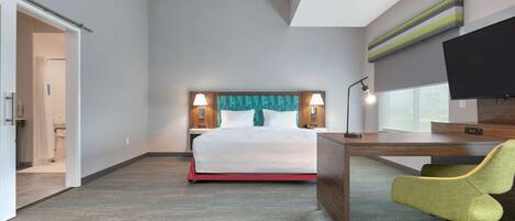 Une chambre d’hôtel équipée d’un lit, d’un bureau, d’une chaise et d’une télévision.