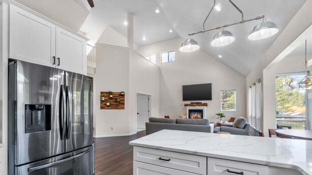 A spacious kitchen with a large stainless steel refrigerator, white cabinetry, and a marble countertop. - River Front House -20 min to Bend -25 min to Mt Bachelor - Sleeps 12 (Bend)
