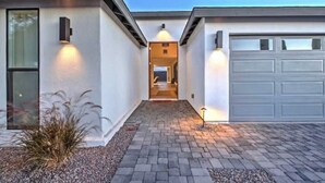 A modern house with a paved driveway, a garage, and a pathway leading to the entrance.