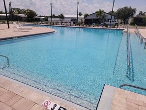 A clear swimming pool with a 'NO DIVING' sign, a 3 FT 6 IN depth marker, and a tiled deck with lounge chairs.