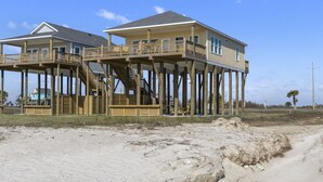 A beachfront house with a wooden deck and multiple levels. - Pelican Shores: Sun, Sand, and Serenity – 3BR Beachfront Retreat! (Gilchrist)