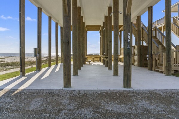 Eine am Strand stehende Holzkonstruktion mit Betonboden und Blick auf den Strand.