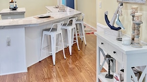 A modern kitchen with a central island, bar stools, pendant lights, and a nautical-themed decor. - Redecorated 3 Bed ,2 Bath ,Sofa bed Outdoor shower Come relax at our beach house (Surfside Beach)