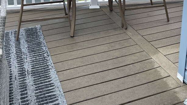 A wooden deck with two wicker chairs and a table, overlooking a body of water and a row of houses. - Redecorated 3 Bed ,2 Bath ,Sofa bed Outdoor shower Come relax at our beach house (Surfside Beach)