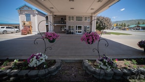 A gas station with a two-story building, a parking lot, and a mountainous backdrop. - Clover Creek Inn (Montpelier)
