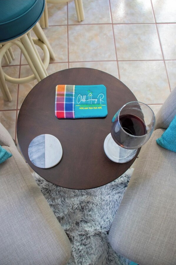 Une petite table ronde avec un set de table, un verre de vin rouge et deux sous-verres ronds.