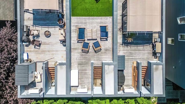 A modern outdoor deck with a pool, lounge chairs, and a barbecue area.