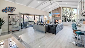 A spacious living area with a fireplace, large windows, and a ceiling fan. - Breathtaking Views, Ideal Location, Peaceful Lounging Area (Sedona)