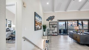 A spacious living area with a staircase, a balcony with a mountain view, and a dining area with a modern design. - Breathtaking Views, Ideal Location, Peaceful Lounging Area (Sedona)
