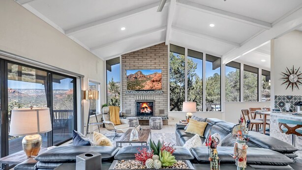 A spacious living room with a fireplace, comfortable seating, and large windows offering views of the outdoors. - Breathtaking Views, Ideal Location, Peaceful Lounging Area (Sedona)