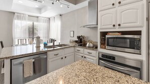 A modern kitchen with granite countertops, white cabinetry, a built-in microwave, and a dishwasher. - •The Gem•Arcade•Covered Parking•Pets•Central! (Euless)