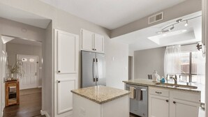 A modern kitchen with white cabinetry, a stainless steel refrigerator, granite countertops, and a window with a view. - •The Gem•Arcade•Covered Parking•Pets•Central! (Euless)