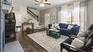 A living room with a blue sofa, a green coffee table, a patterned rug, and a staircase. - •The Gem•Arcade•Covered Parking•Pets•Central! (Euless)