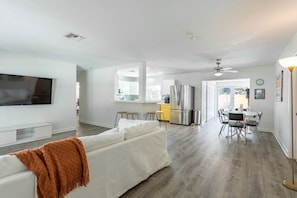 Relax in a spacious living area with a sofa and flat-screen TV, and enjoy meals in the dining area with a table and chairs.