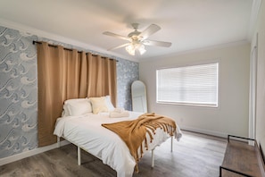 Cozy retreat with a single bed, ceiling fan, and window with blinds.