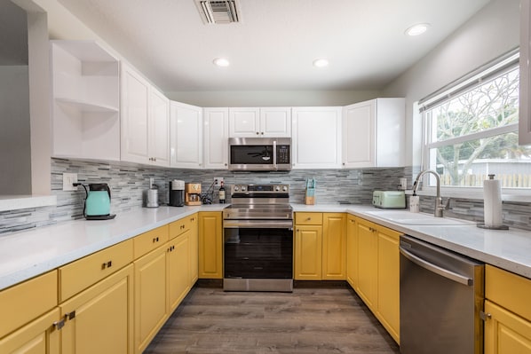 Enjoy cooking in this well-equipped kitchen with a range hood, microwave, and dishwasher.
