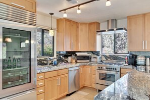Enjoy cooking in this well-equipped kitchen with a refrigerator, oven, microwave, dishwasher, and sink.