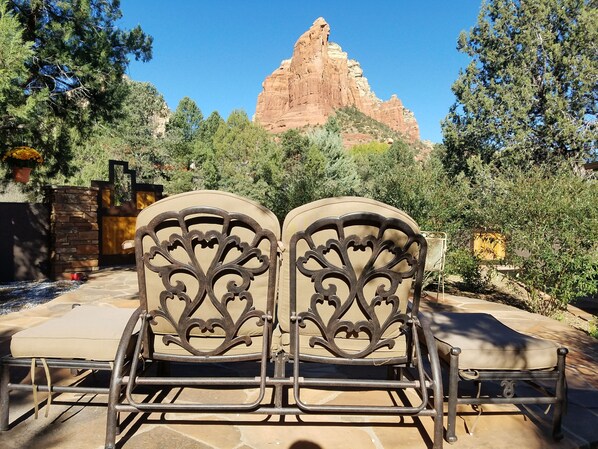 Relax in style on the patio with a pair of comfortable chairs overlooking a stunning rock formation.